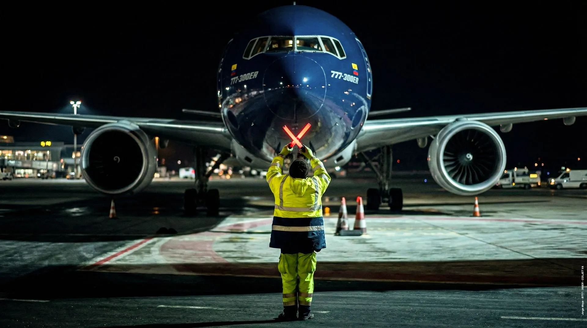 Boeing 777-300ER de COLJET guiado por un señalero en la noche
